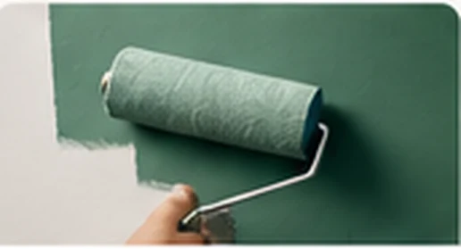 Paint roller applying green paint to a wall
